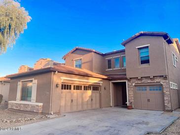Two story home with a three car garage and desert landscaping at 15685 W Mackenzie Dr, Goodyear, AZ 85395