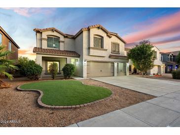 Two-story house with artificial turf front yard at 15163 W Cameron Dr, Surprise, AZ 85379