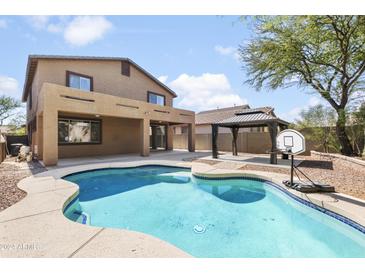 Inviting kidney-shaped pool with a large backyard at 4512 W Stoneman Dr, Anthem, AZ 85086