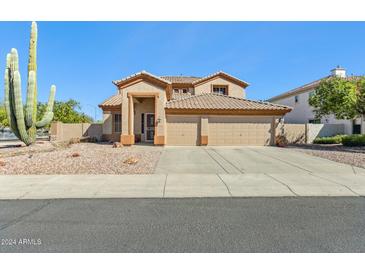 Two-story house with a three-car garage and desert landscaping at 19435 N 62Nd Ave, Glendale, AZ 85308