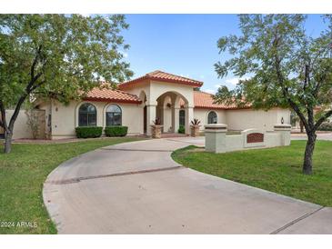 Spanish style home with a large driveway and manicured lawn at 591 E Park Ave, Gilbert, AZ 85234