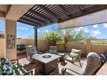 Relaxing patio with fire pit and seating area, perfect for outdoor entertaining at 9033 E Ivyglen Cir, Mesa, AZ 85207