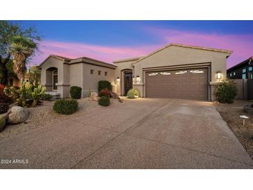 Single-story home with desert landscaping and two-car garage at 34599 N 99Th Way, Scottsdale, AZ 85262