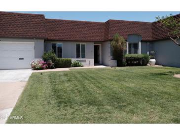 Attractive condo with brown roof, attached garage, and neatly landscaped front yard at 3114 E Hazelwood St, Phoenix, AZ 85016