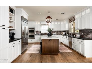 Spacious kitchen with white cabinets, a large island, and hardwood floors at 88 N Country Club Dr, Phoenix, AZ 85014