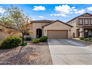Tan house with two-car garage and landscaping at 1095 W Desert Valley Dr, San Tan Valley, AZ 85143