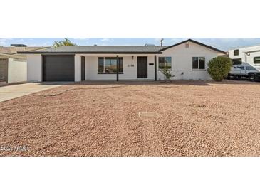 Newly remodeled home with a white exterior and dark gray garage door at 5714 N 19Th Dr, Phoenix, AZ 85015