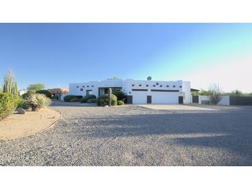 White stucco house with a three-car garage and desert landscaping at 27824 N 256Th Ave, Wittmann, AZ 85361