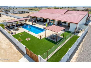 Aerial view of house, pool, and backyard with artificial turf and pergola at 5604 S 225Th Ave, Buckeye, AZ 85326