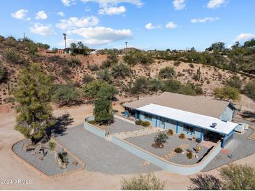 Aerial view of a ranch-style home with a gravel driveway and desert landscaping at 51027 N 297Th Ave, Wickenburg, AZ 85390