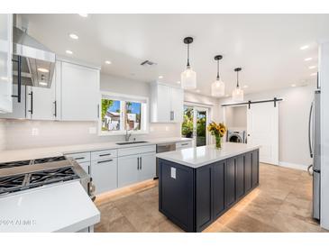 Modern kitchen with white cabinets, quartz countertops, and a large island at 8431 E Via De Encanto --, Scottsdale, AZ 85258