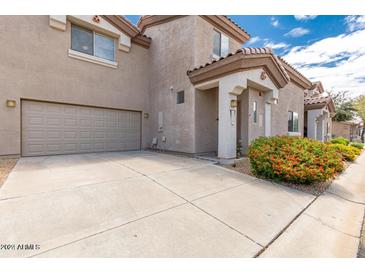 Tan two-story townhome with a garage and landscaping at 7959 W Waltann Ln, Peoria, AZ 85382