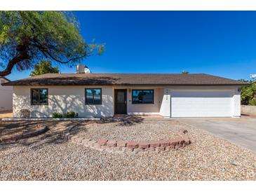 Single-story home with a white exterior and a gravel yard at 15840 N 22Nd St, Phoenix, AZ 85022