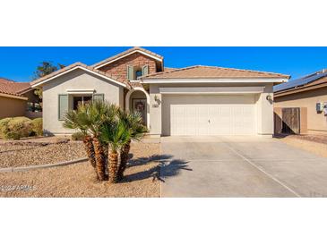 House exterior with a two-car garage and desert landscaping at 980 S 220Th Ln, Buckeye, AZ 85326