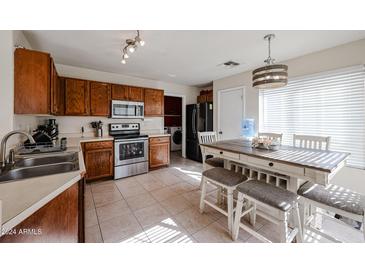 Kitchen with stainless steel appliances and a wooden table at 1098 E Nardini St, San Tan Valley, AZ 85140