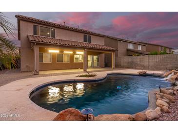 Home with a large kidney shaped pool and covered patio at 20293 N 83Rd Dr, Peoria, AZ 85382