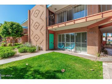 Condo building exterior with landscaped lawn and walkway at 103 E Palm Ln # A, Phoenix, AZ 85004