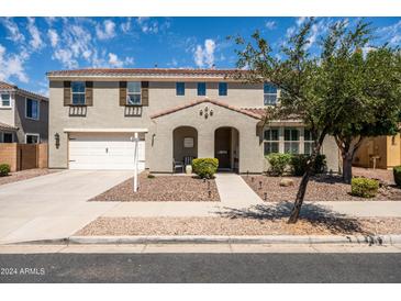 Two-story house with a white door, two-car garage, and landscaping at 21030 E Misty Ln, Queen Creek, AZ 85142