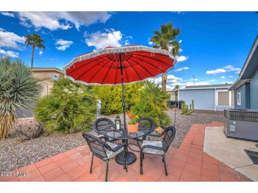 Patio with table and chairs, umbrella, and desert landscaping at 2400 E Baseline Ave # 112, Apache Junction, AZ 85119