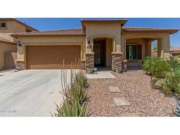 Tan house with brown garage door and stone accents at 5526 S Grenoble St, Mesa, AZ 85212