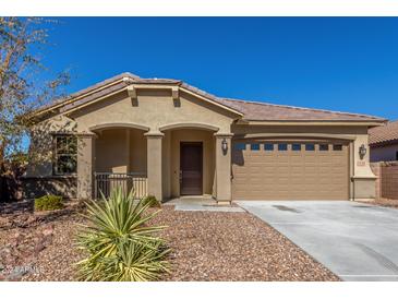 Tan two-car garage home with desert landscaping at 43958 W Stonecreek Rd, Maricopa, AZ 85139