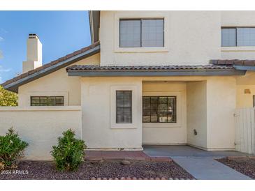 Exterior view of a light-colored two-story home with a small patio and landscaping at 1222 W Baseline Rd # 121, Tempe, AZ 85283