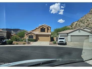 Two-story house with a tan exterior, two-car garage, and mountain views at 1416 E Sapium Way, Phoenix, AZ 85048