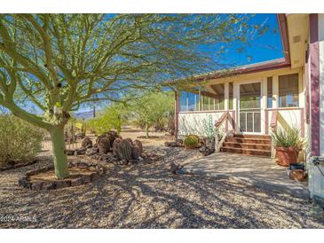 Desert landscape home with porch and cacti at 50910 W Long Rifle Rd, Aguila, AZ 85320