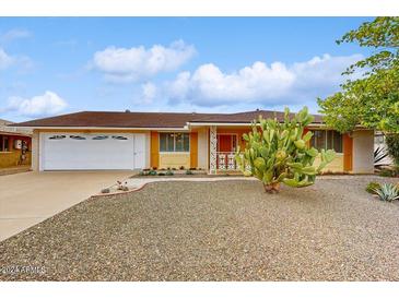 Ranch-style home with a two-car garage and desert landscaping at 10506 W Desert Forest Cir, Sun City, AZ 85351