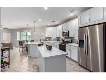 Open concept kitchen with white cabinets and a large island at 2511 W Queen Creek Rd # 205, Chandler, AZ 85248