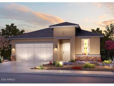 Single-story home with a three-car garage and desert landscaping at 20640 N Confetti Ct, Maricopa, AZ 85138