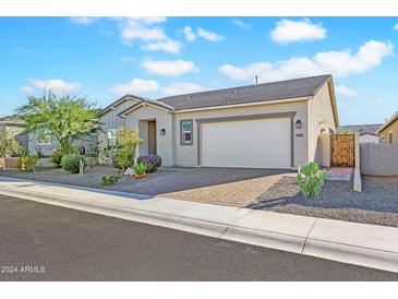 Tan house with desert landscaping and a two-car garage at 17917 W Amberwood Dr, Goodyear, AZ 85338