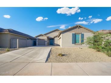 Single-story home with a landscaped front yard and a two-car garage at 23376 W Miami St, Buckeye, AZ 85326