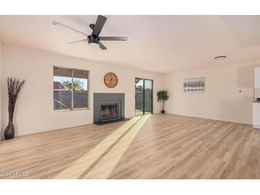 Spacious living room featuring hardwood floors, a fireplace, and sliding glass doors at 4601 W Wilshire Dr, Phoenix, AZ 85035