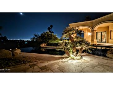 Night view of a luxurious pool and patio area at 4836 E White Gates Dr, Phoenix, AZ 85018