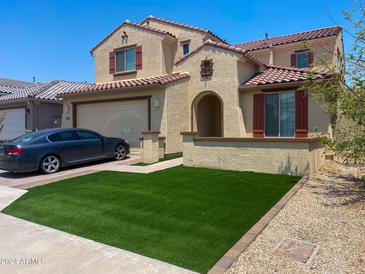 Two-story house with a two-car garage and artificial turf at 5819 N 88Th Ln, Glendale, AZ 85305