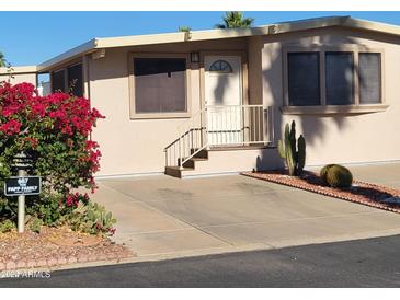 Tan single-wide manufactured home with carport and desert landscaping at 17200 W Bell Rd # 667, Surprise, AZ 85374