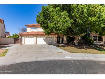 Beautiful two-story home with a three-car garage and lush landscaping at 5702 W Windrose Dr, Glendale, AZ 85304
