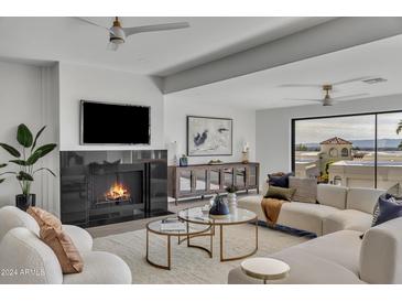 Bright living room with a fireplace, large windows, and comfortable seating at 3800 E Lincoln Dr # 42, Phoenix, AZ 85018
