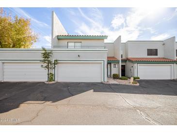 Two-story stucco townhouse with attached garage and front patio at 6705 W Orchid Ln, Peoria, AZ 85345