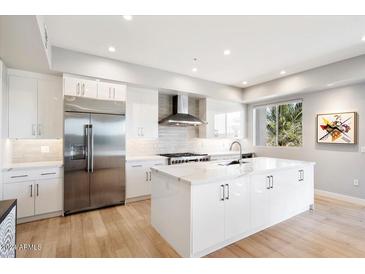 Modern kitchen with white cabinets, large island, and stainless steel appliances at 16580 N 92Nd St # 2001, Scottsdale, AZ 85260
