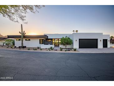 Modern home with white stucco exterior, black accents, and two-car garage at 5525 E Lincoln Dr # 124, Paradise Valley, AZ 85253