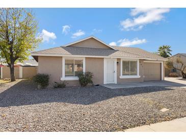 One-story house with a neutral exterior, a two-car garage, and a rock-covered front yard at 951 E Halifax St, Mesa, AZ 85203