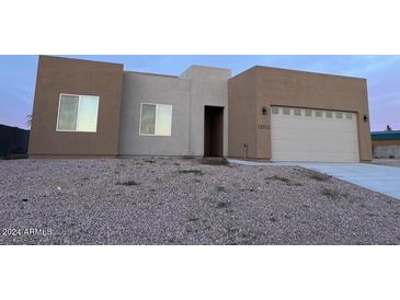 Two-story stucco home with a two-car garage and gravel landscaping at 11702 W Delwood Dr, Arizona City, AZ 85123