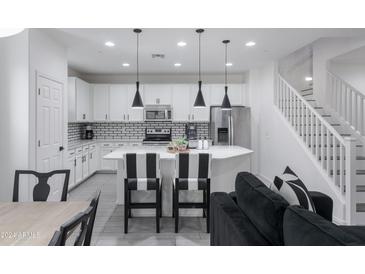 Modern kitchen with white cabinets, island, and black and white accents at 4636 E Tierra Buena Ln, Phoenix, AZ 85032