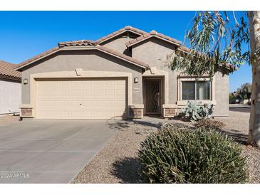 Tan house with a beige garage door and landscaped front yard at 28629 N Zircon Ct, San Tan Valley, AZ 85143
