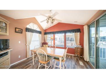 Charming dining area with a wooden table and chairs, near a sliding glass door at 648 Hawks Eye Dr # 648, Apache Junction, AZ 85119