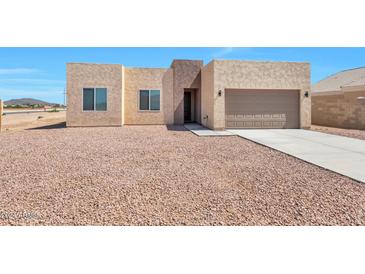 Front view of a newly built house with a gravel yard at 9121 W Debbie Ln, Arizona City, AZ 85123