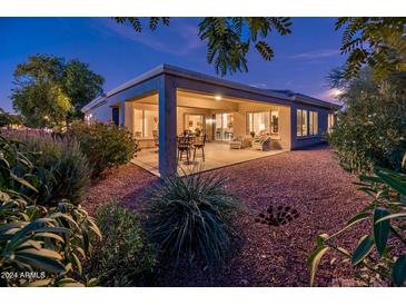 House exterior with covered patio at night at 13431 W Los Bancos Dr, Sun City West, AZ 85375