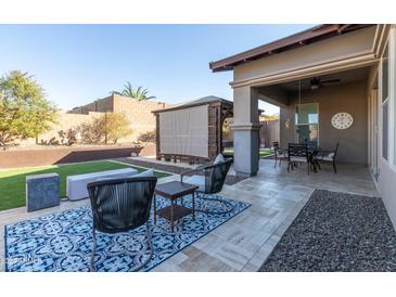 Landscaped backyard with patio furniture, artificial turf, and a pergola at 18518 W Acacia Dr, Goodyear, AZ 85338